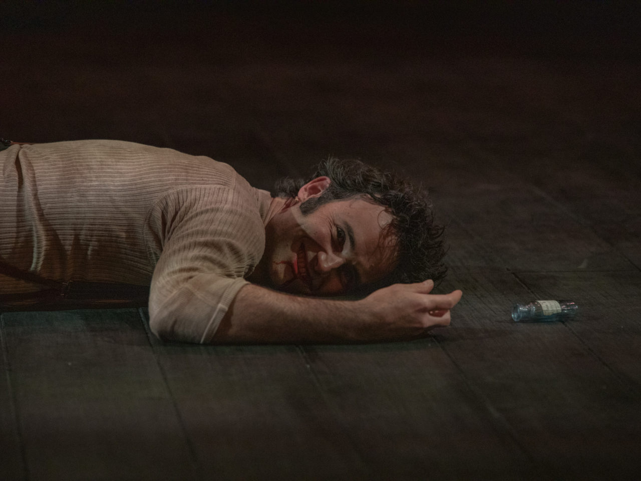 Nicholas Shaw (Jekyll and Hyde) is lay on the stage floor, he is smiling menacingly.
