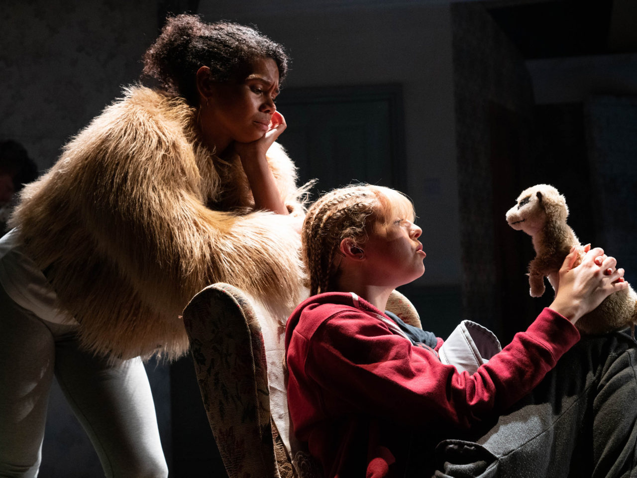 Kate and Martha stare at the toy meerkat in the production Home Girl.