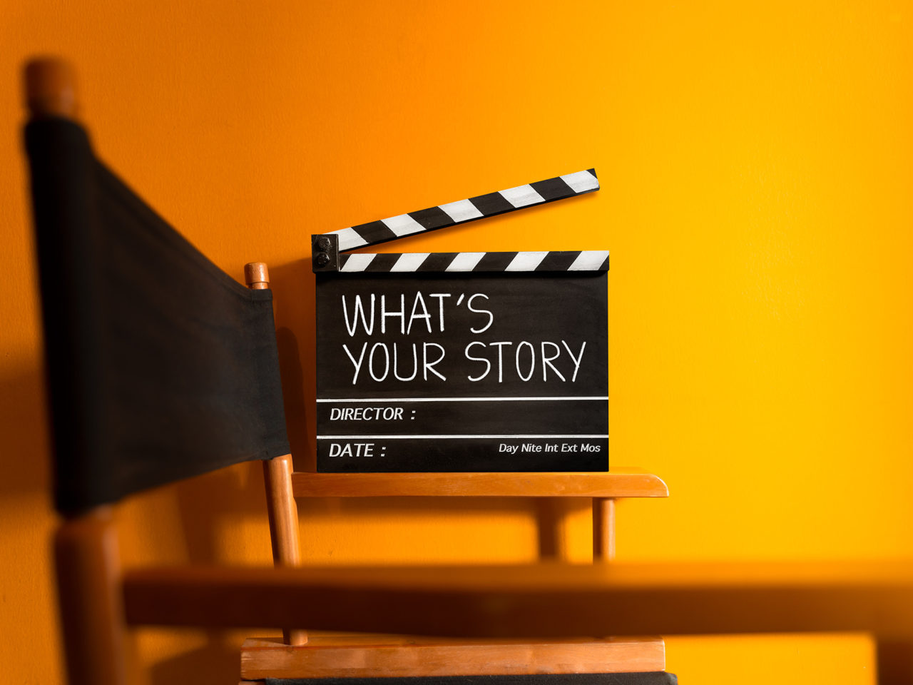 A clapper board with the words 'What's Your Story?'